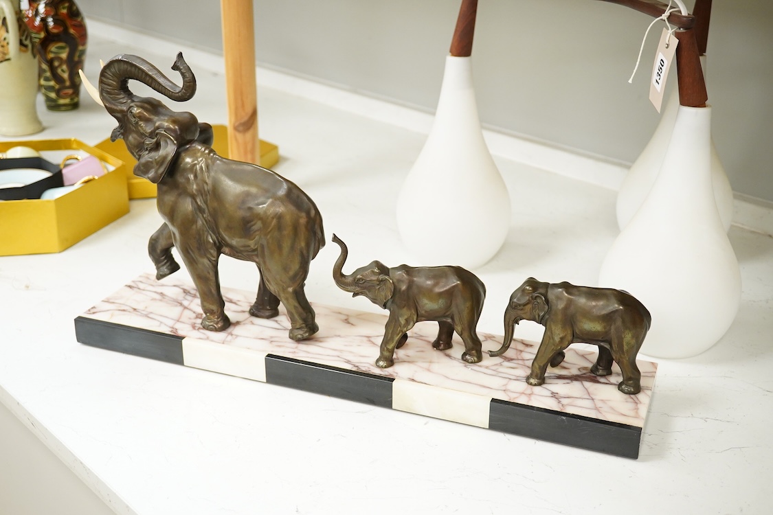 An Art Deco study, three spelter elephants, raised on marble and onyx base, 54cm wide